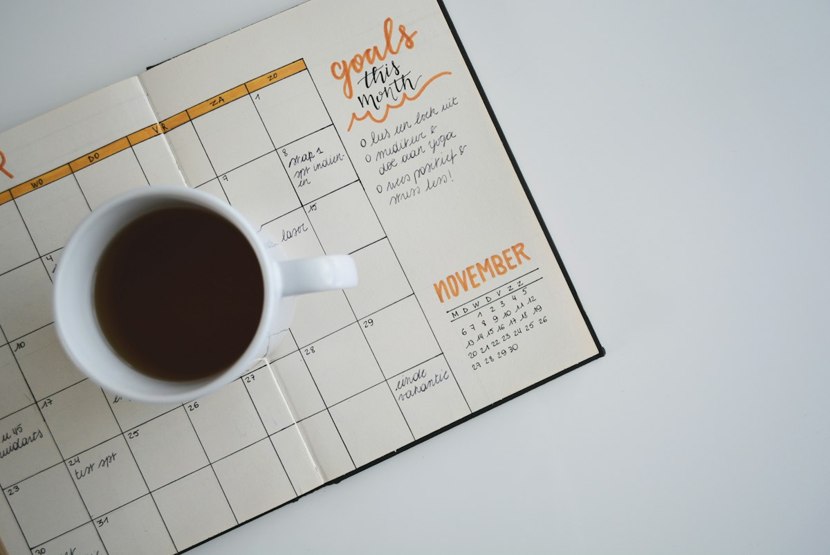 Vintage wooden desk calendar with flip blocks, open planner journal, and fountain pen